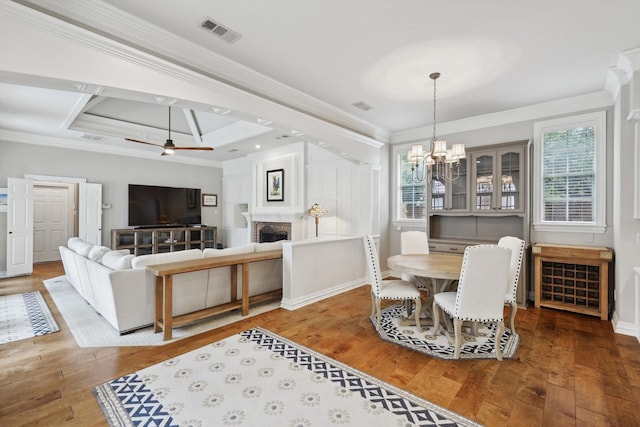 dining area featuring hardwood / wood-style floors, ornamental molding, and a wealth of natural light