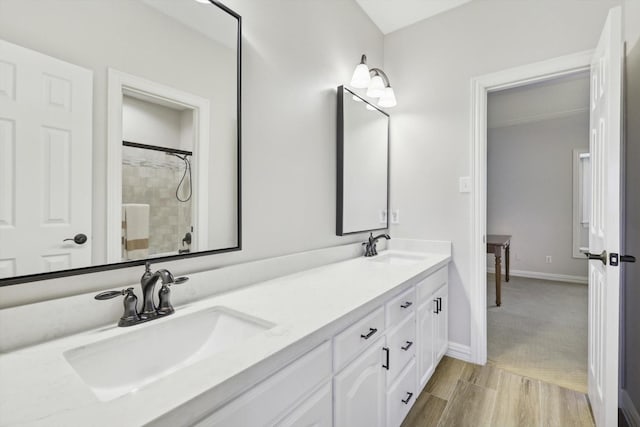 bathroom featuring hardwood / wood-style floors, vanity, and a shower