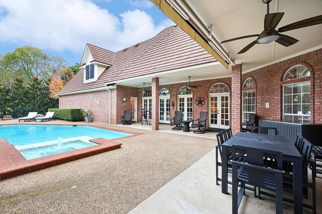 view of swimming pool with ceiling fan, a patio area, and french doors