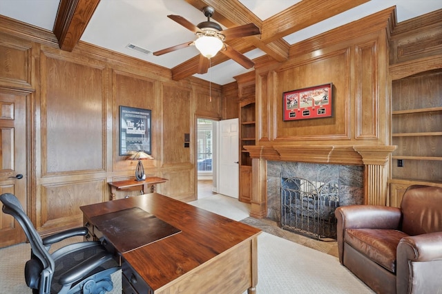 office area with beam ceiling, built in features, ceiling fan, and wooden walls