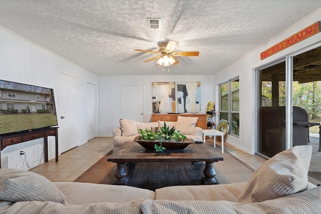 living room with ornamental molding, ceiling fan, and light tile patterned flooring