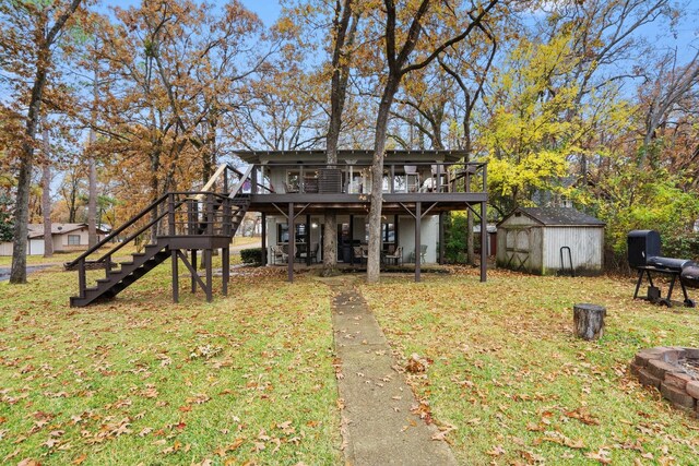 rear view of house featuring a lawn, a wooden deck, and a storage shed