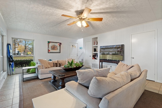 living room featuring tile patterned flooring, built in features, and ceiling fan