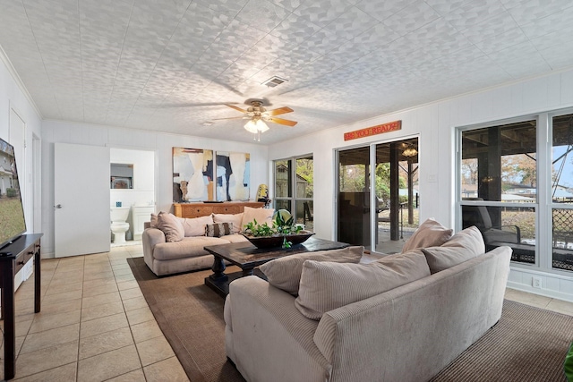 living room with ornamental molding, light tile patterned floors, and ceiling fan