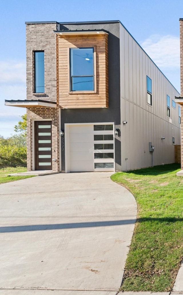 contemporary house featuring a garage and a front lawn