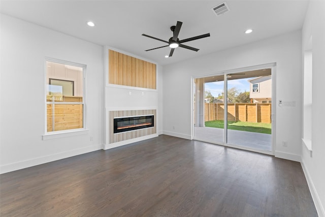 unfurnished living room featuring ceiling fan and dark wood-type flooring