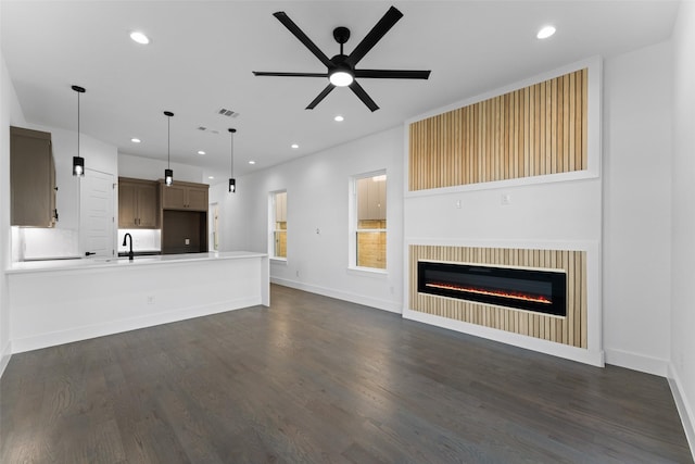 unfurnished living room with dark hardwood / wood-style floors and ceiling fan