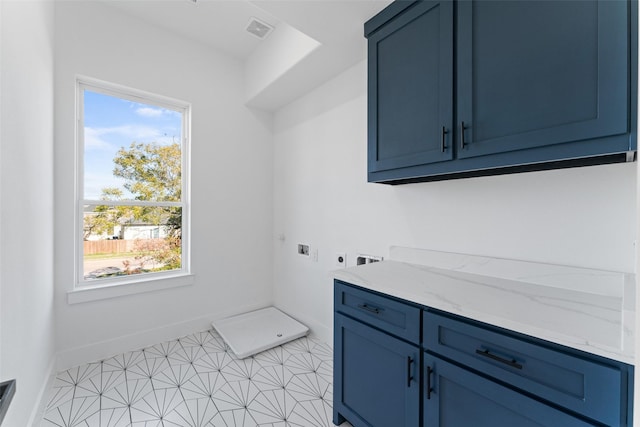 clothes washing area featuring hookup for an electric dryer, cabinets, light tile patterned floors, and a wealth of natural light