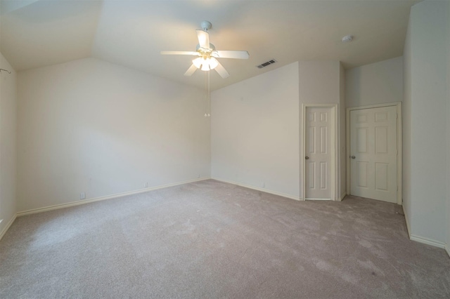 carpeted empty room featuring vaulted ceiling and ceiling fan