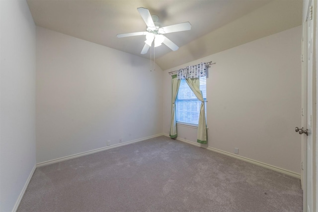 carpeted empty room featuring vaulted ceiling and ceiling fan