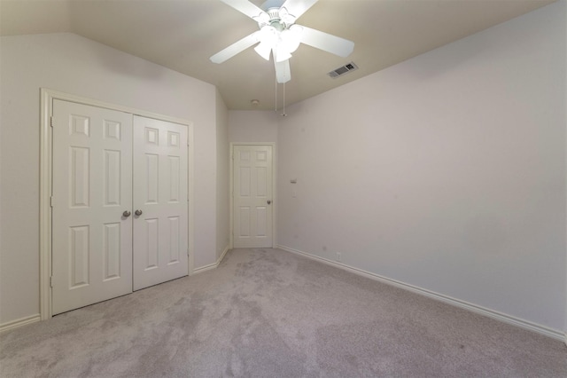 unfurnished bedroom with ceiling fan, light colored carpet, and a closet