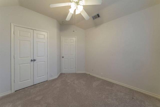 unfurnished bedroom featuring ceiling fan, a closet, lofted ceiling, and carpet