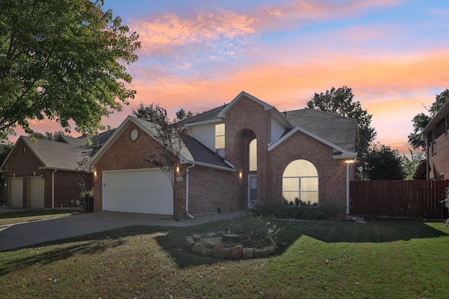 front of property with a garage and a lawn