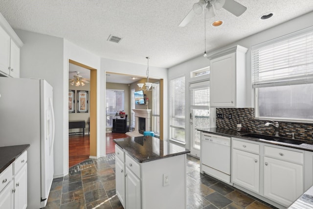 kitchen featuring white cabinetry, sink, tasteful backsplash, decorative light fixtures, and white appliances