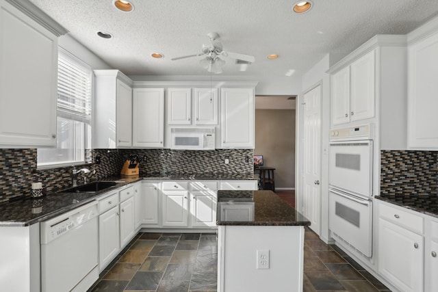 kitchen featuring decorative backsplash, white appliances, white cabinetry, and sink