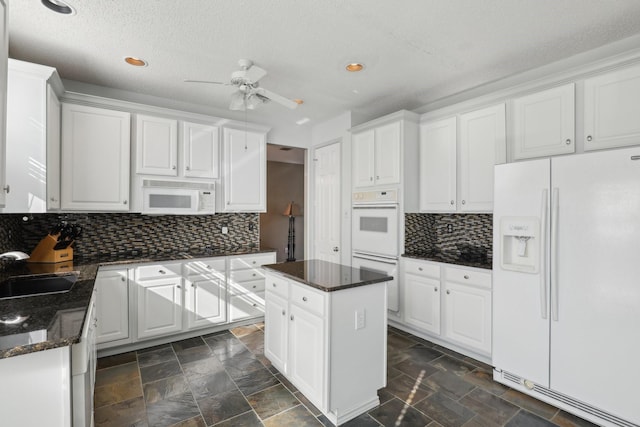 kitchen with white cabinetry, a center island, white appliances, and sink