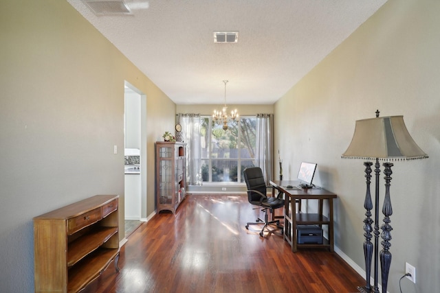 office area with a textured ceiling, dark hardwood / wood-style floors, and a notable chandelier