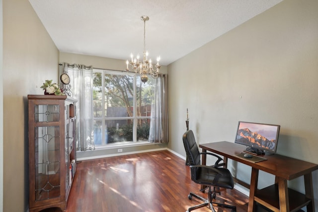 home office featuring dark wood-type flooring and a notable chandelier