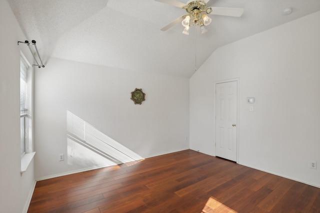 unfurnished room featuring ceiling fan, dark hardwood / wood-style flooring, a textured ceiling, and vaulted ceiling