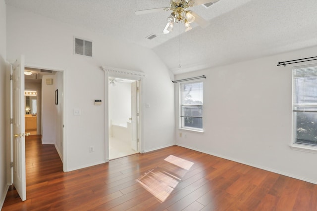 unfurnished bedroom featuring ceiling fan, dark hardwood / wood-style floors, a textured ceiling, and vaulted ceiling