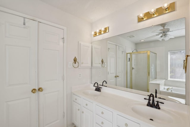 bathroom with ceiling fan, vanity, independent shower and bath, and a textured ceiling