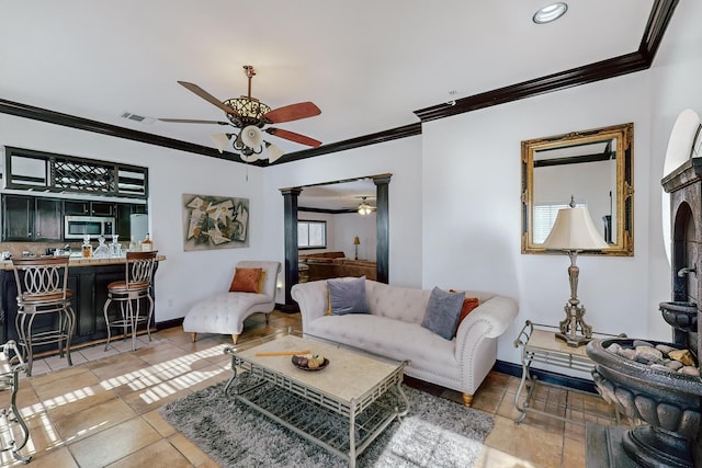 tiled living room featuring crown molding and ceiling fan