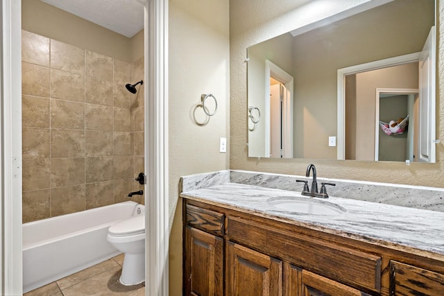 full bathroom featuring vanity, tiled shower / bath combo, tile patterned floors, and toilet