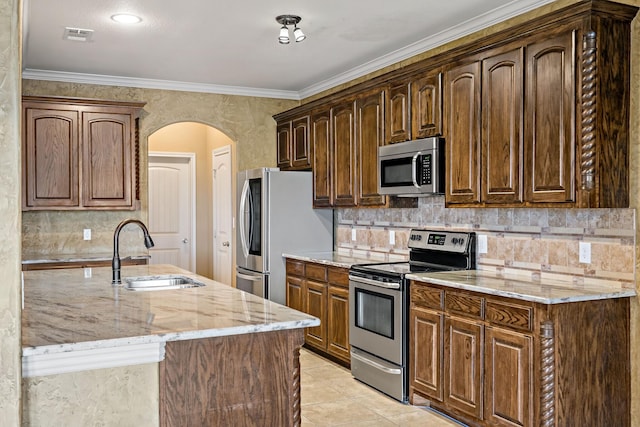 kitchen featuring appliances with stainless steel finishes, sink, decorative backsplash, ornamental molding, and light stone counters