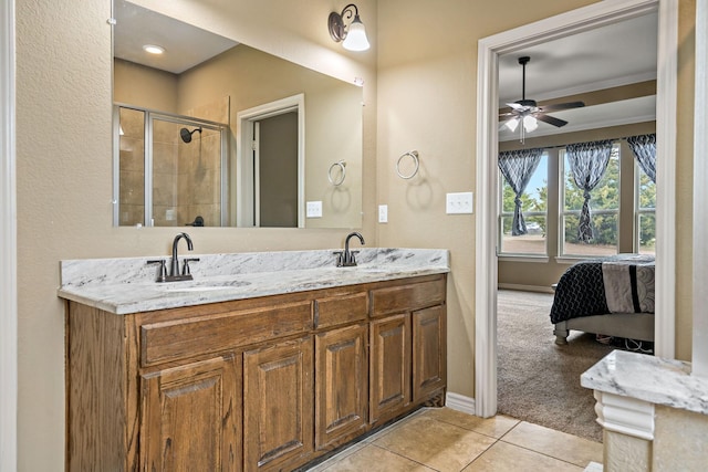 bathroom with tile patterned floors, vanity, ceiling fan, crown molding, and a shower with shower door