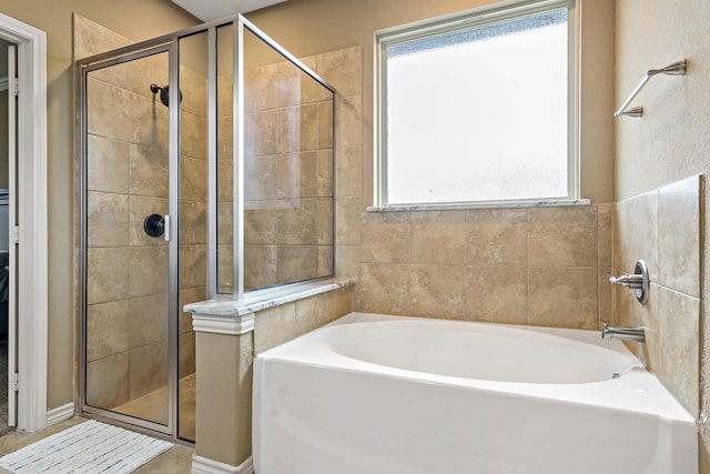 bathroom with a healthy amount of sunlight and independent shower and bath