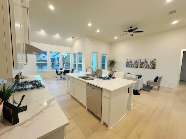 kitchen with white cabinetry, sink, stainless steel appliances, a kitchen island with sink, and light wood-type flooring