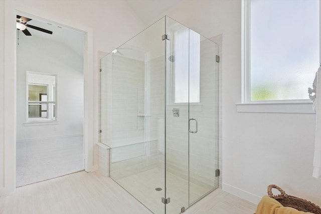 bathroom featuring ceiling fan, a shower with shower door, and lofted ceiling