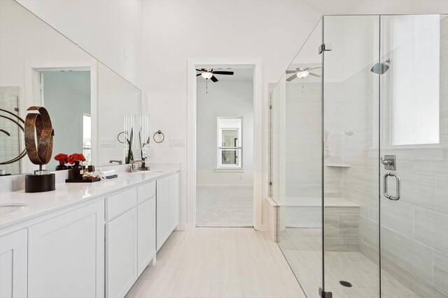 bathroom featuring ceiling fan, vanity, a healthy amount of sunlight, and an enclosed shower