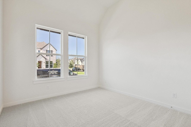 empty room featuring carpet flooring and lofted ceiling