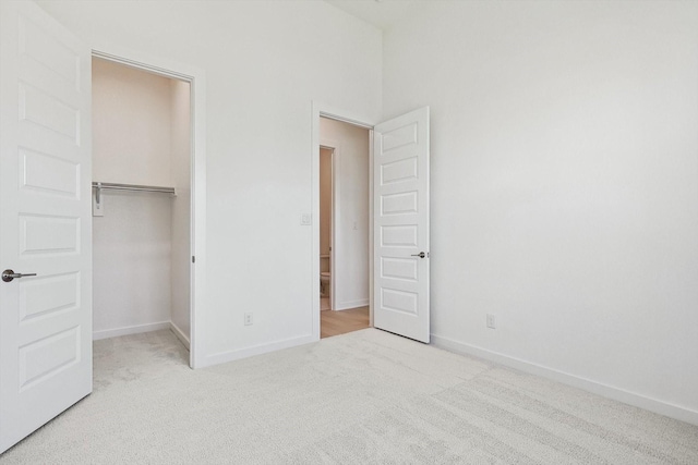 unfurnished bedroom featuring light carpet and a closet