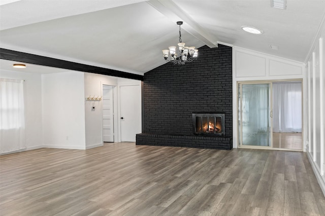 unfurnished living room featuring vaulted ceiling with beams, brick wall, a notable chandelier, wood-type flooring, and a fireplace