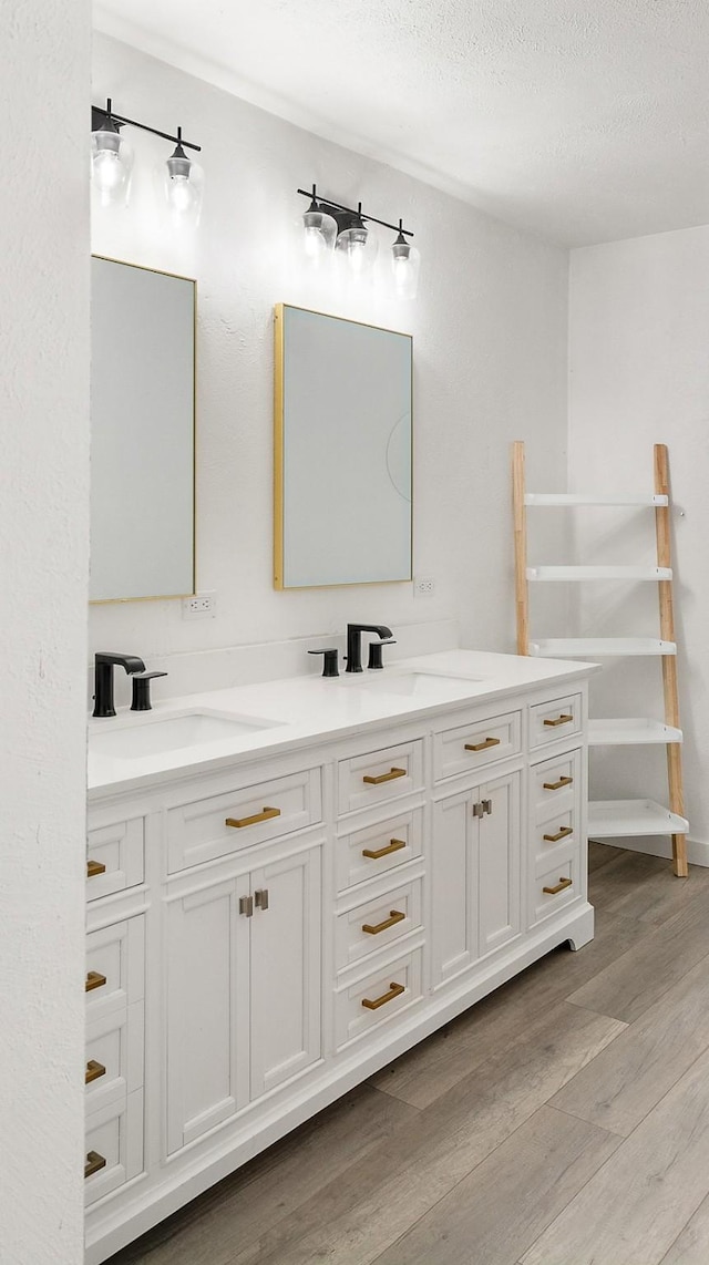 bathroom featuring hardwood / wood-style floors, vanity, and a textured ceiling