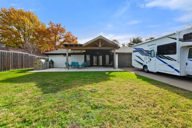 rear view of house with a patio and a lawn