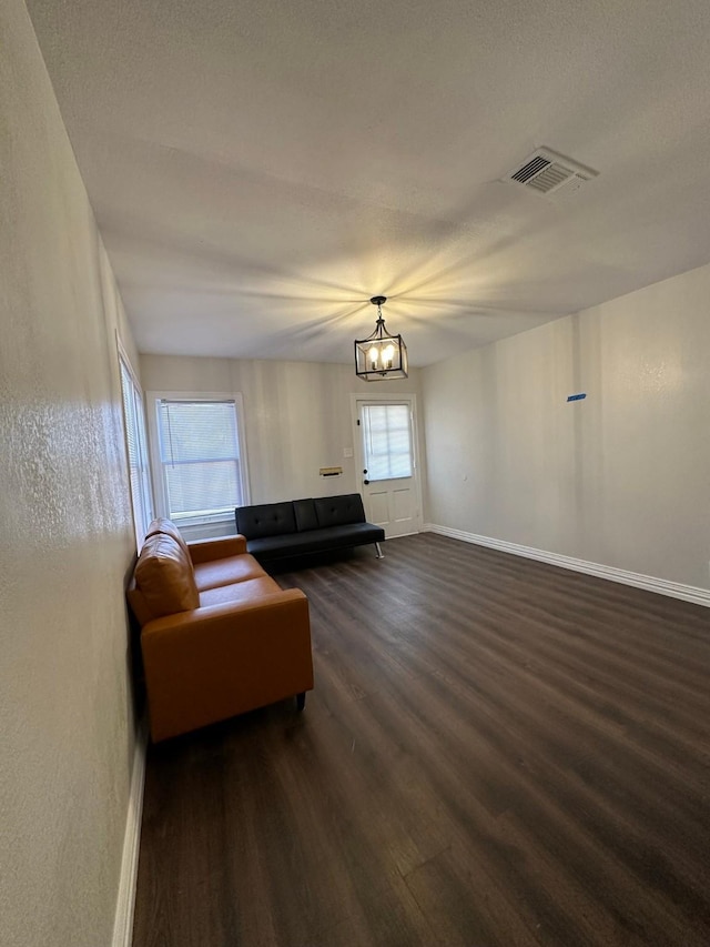 living room with a notable chandelier and dark hardwood / wood-style floors