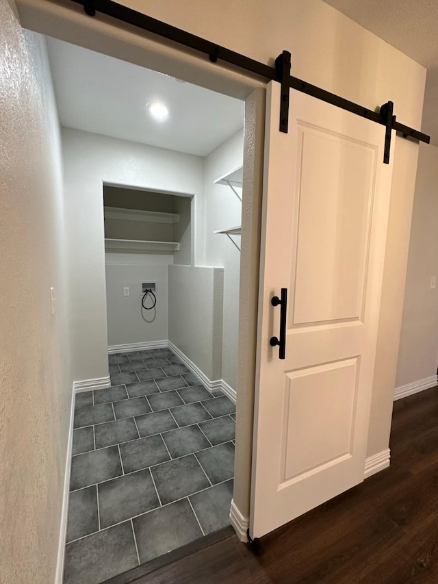 washroom with dark hardwood / wood-style flooring, a barn door, and hookup for a washing machine