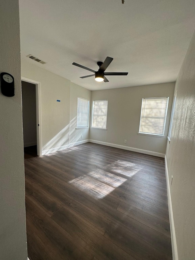 unfurnished room with ceiling fan and dark wood-type flooring