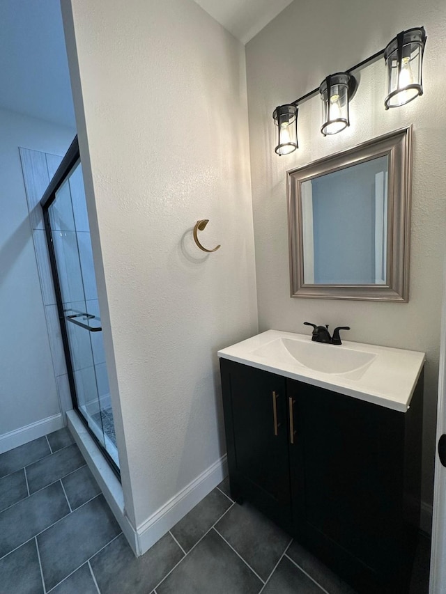 bathroom with tile patterned flooring, vanity, and a shower with door