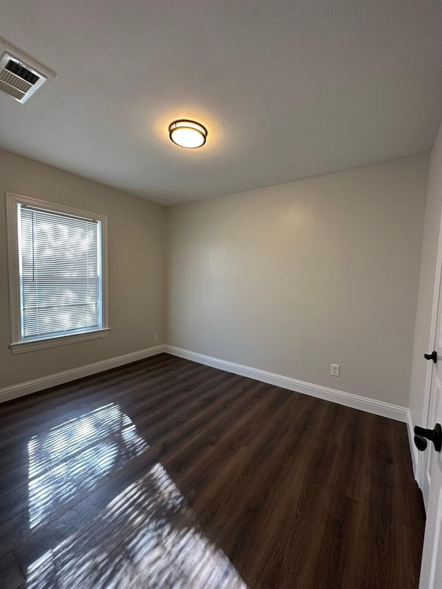 empty room with dark hardwood / wood-style flooring