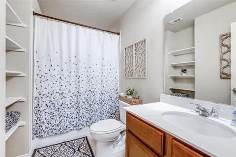 bathroom with vanity, curtained shower, and toilet