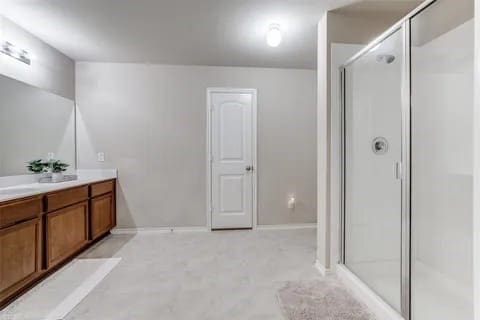 bathroom with vanity and a shower with door