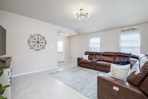 living room with carpet, an inviting chandelier, and a healthy amount of sunlight