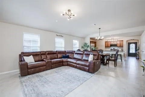 living room with vaulted ceiling, an inviting chandelier, and a healthy amount of sunlight