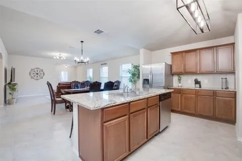 kitchen featuring stainless steel appliances, sink, a center island, hanging light fixtures, and a breakfast bar area