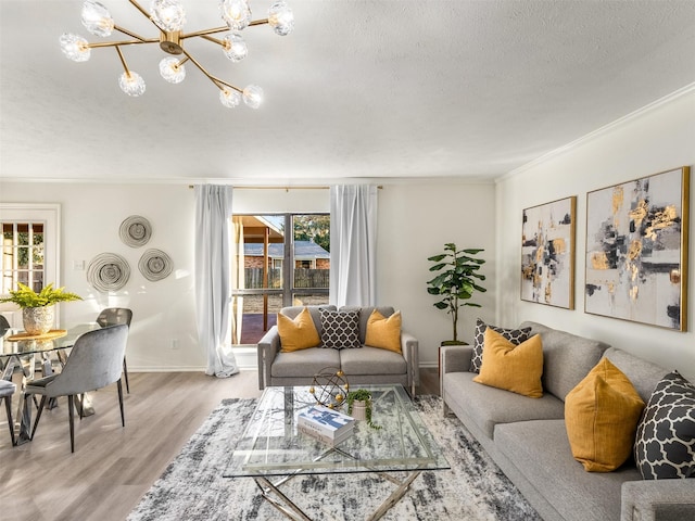 living room with hardwood / wood-style flooring, crown molding, a textured ceiling, and a chandelier