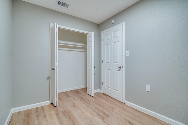 unfurnished bedroom with a closet and light wood-type flooring